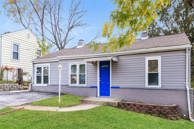 9608 Flora Ave, Saint Louis, MO 63114 - view of front facade featuring a chimney, a front yard, and brick siding