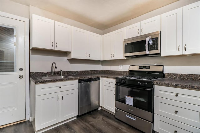 9608 Flora Ave, Saint Louis, MO 63114 - kitchen with stainless steel appliances, a sink, dark wood finished floors, and dark countertops