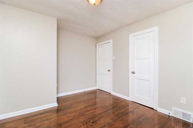9608 Flora Ave, Saint Louis, MO 63114 - spare room featuring wood finished floors, baseboards, and a textured ceiling