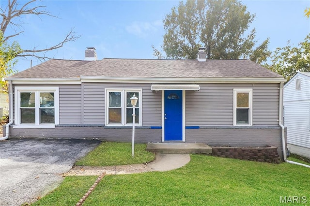9608 Flora Ave, Saint Louis, MO 63114 - view of front of property with a chimney, a front lawn, brick siding, and roof with shingles
