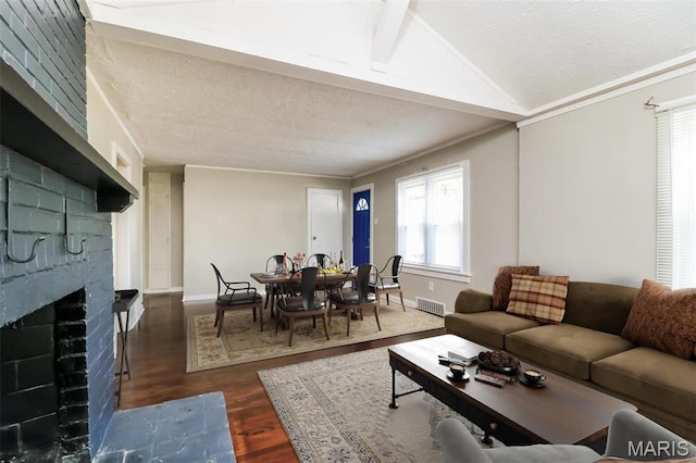 9608 Flora Ave, Saint Louis, MO 63114 - living area with dark wood-style flooring, a fireplace, vaulted ceiling, a textured ceiling, and baseboards