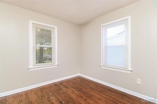 9608 Flora Ave, Saint Louis, MO 63114 - unfurnished room featuring baseboards and dark wood-style flooring