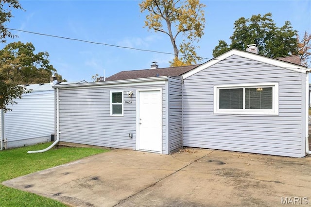 9608 Flora Ave, Saint Louis, MO 63114 - back of house with a patio area, a chimney, and a lawn