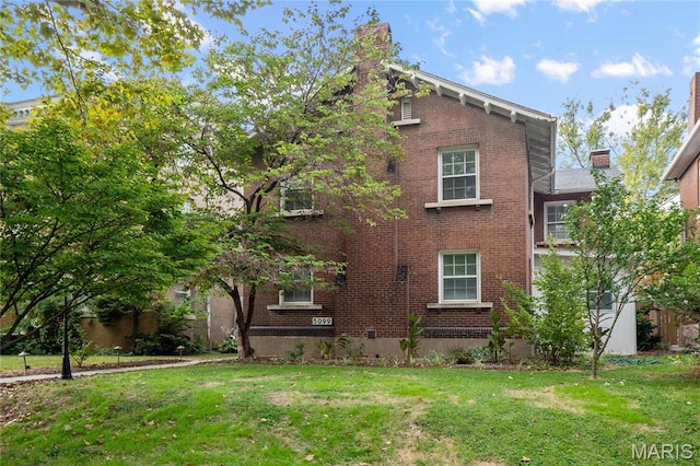 5099 Waterman Blvd, Saint Louis, MO 63108 - view of side of property with brick siding, a chimney, and a lawn