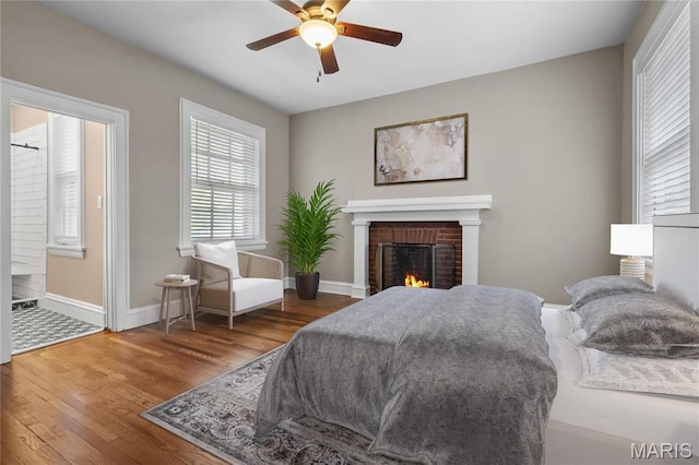 5099 Waterman Blvd, Saint Louis, MO 63108 - bedroom with wood finished floors, baseboards, a brick fireplace, and a ceiling fan