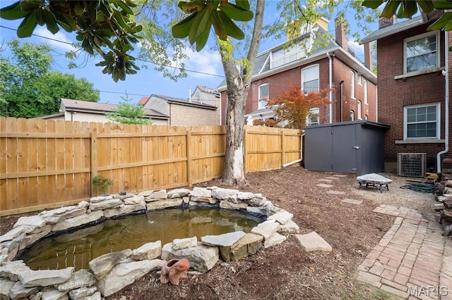 5099 Waterman Blvd, Saint Louis, MO 63108 - fenced backyard with central AC unit and a garden pond