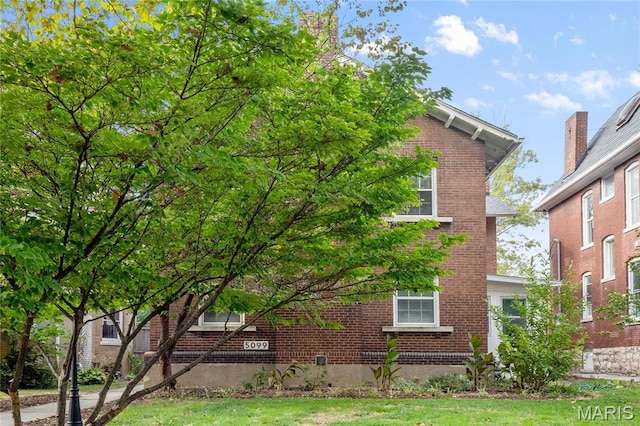 5099 Waterman Blvd, Saint Louis, MO 63108 - view of side of home with brick siding and a lawn