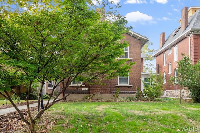 5099 Waterman Blvd, Saint Louis, MO 63108 - view of side of home featuring brick siding and a lawn
