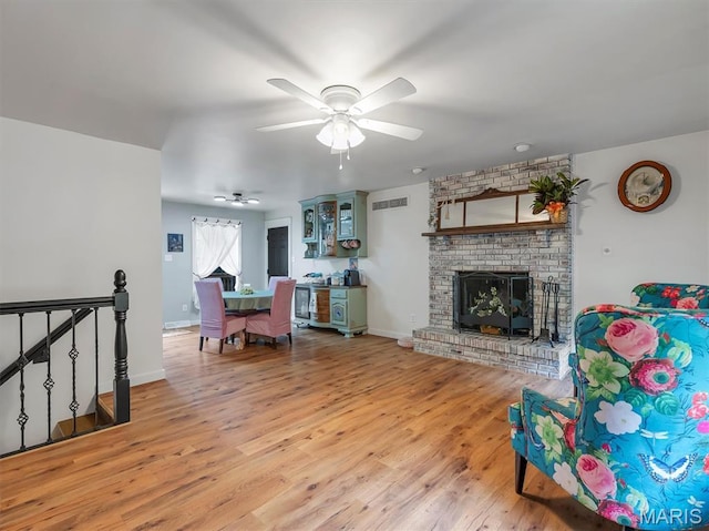 575 E Villa Ridge Rd, Villa Ridge, MO 63089 - living room featuring light wood-type flooring, a ceiling fan, and a brick fireplace