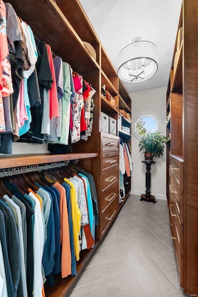 walk in closet featuring a chandelier