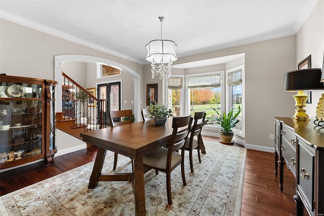dining area with stairs, arched walkways, ornamental molding, a chandelier, and hardwood / wood-style floors