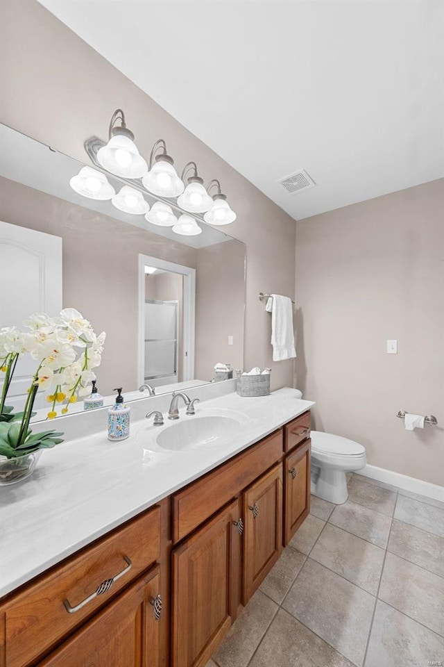 bathroom with vanity, toilet, tile patterned flooring, and baseboards