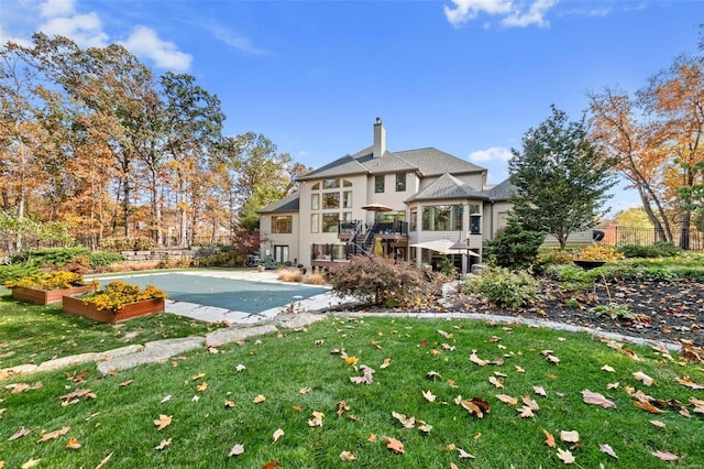 back of property featuring a chimney and a vegetable garden