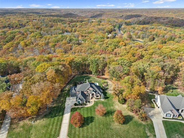 aerial view of property and surrounding area with a heavily wooded area