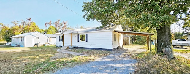 view of front of home featuring gravel driveway, crawl space, a carport, and metal roof