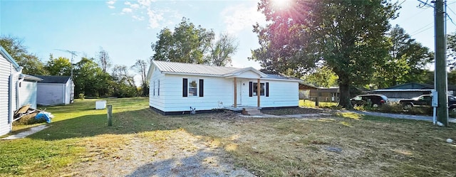 view of front of property with a front lawn and metal roof