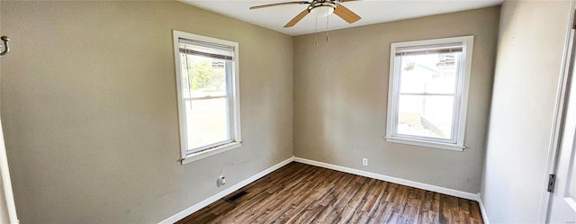 empty room featuring a ceiling fan, dark wood-style flooring, and baseboards
