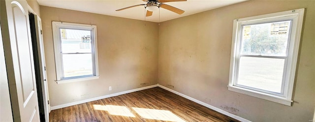 spare room with baseboards, wood finished floors, and ceiling fan