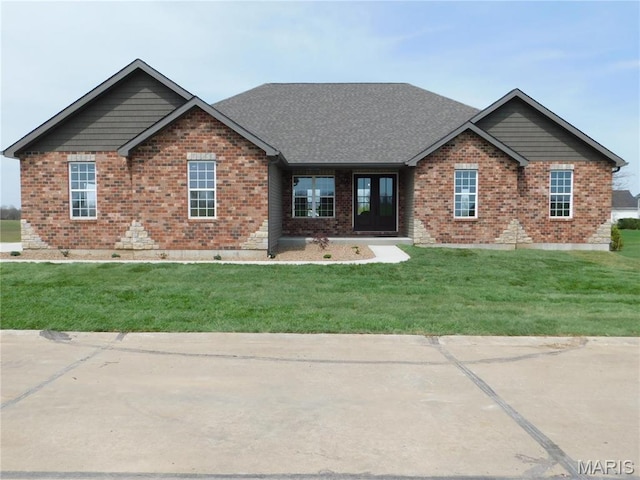view of front of house featuring brick siding and a front lawn