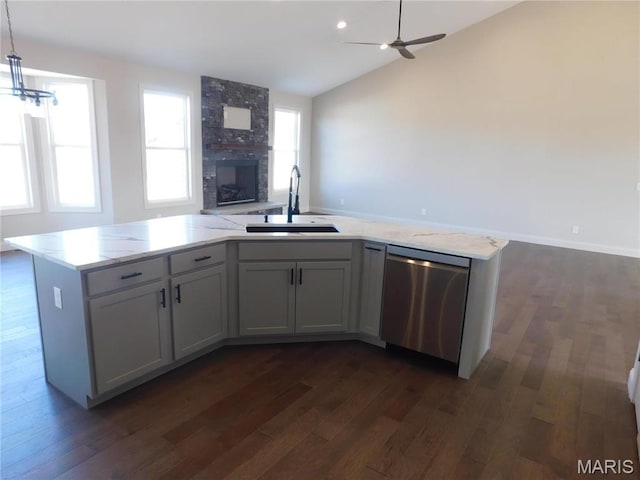 kitchen featuring stainless steel dishwasher, a sink, open floor plan, lofted ceiling, and dark wood finished floors