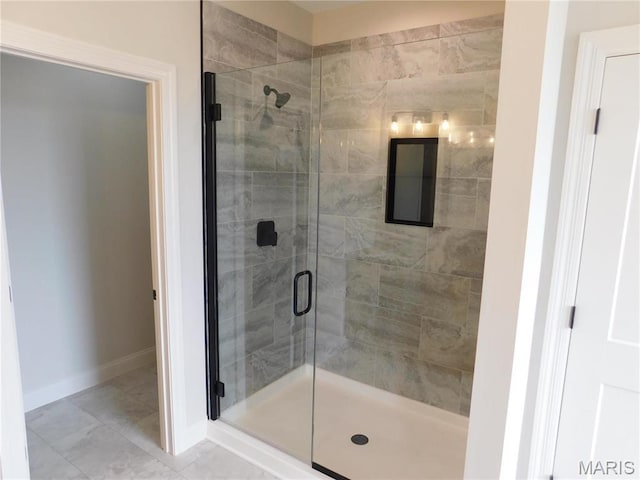 bathroom with a stall shower and baseboards