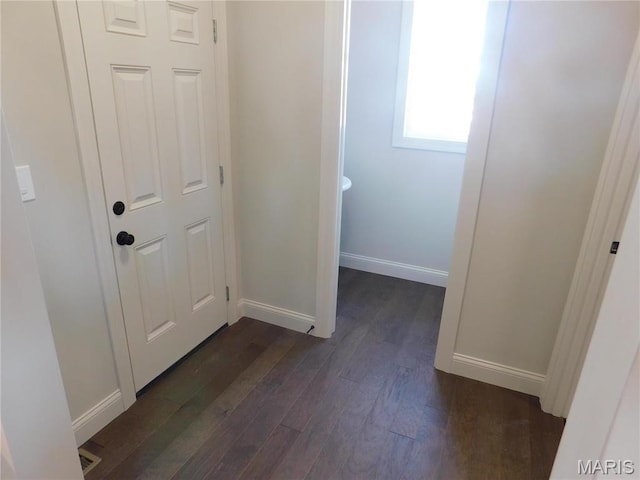 hall with dark wood-style floors and baseboards