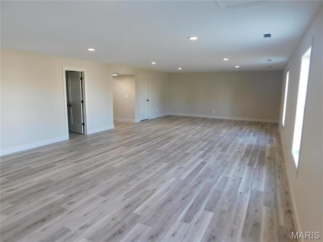 empty room with light wood-type flooring, recessed lighting, and baseboards