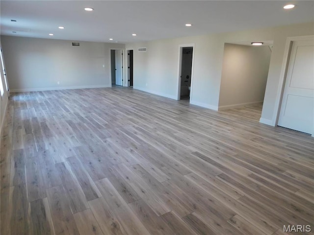 spare room with wood finished floors, recessed lighting, and baseboards