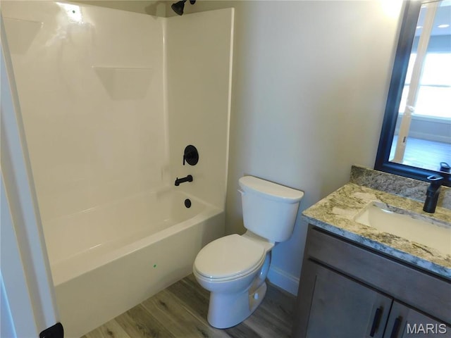 full bath with toilet, wood finished floors, shower / tub combination, and vanity