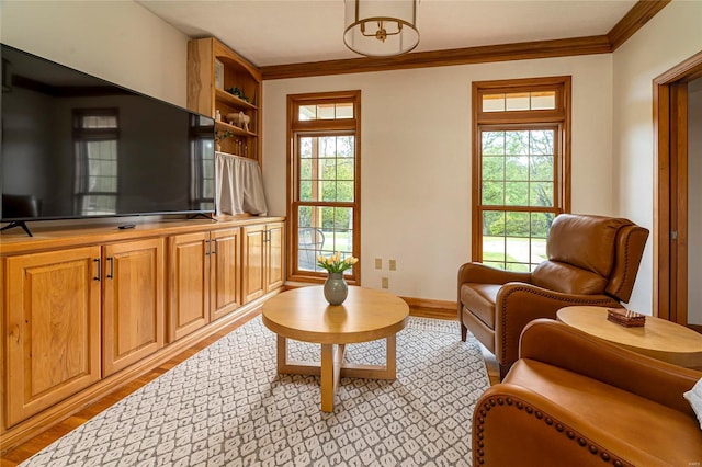 living area with ornamental molding, light wood finished floors, and baseboards