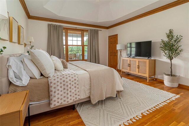 bedroom with ornamental molding and wood finished floors