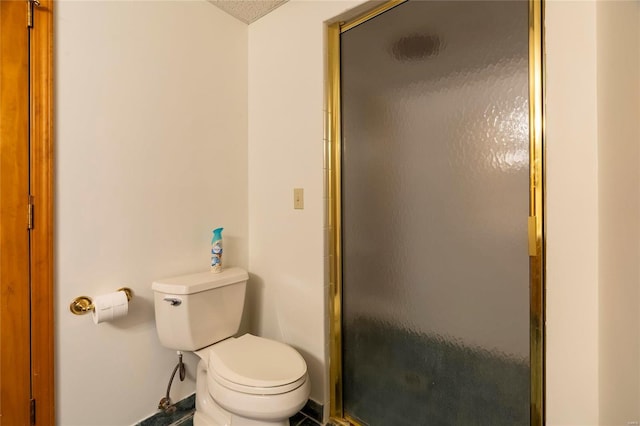 full bath with a stall shower, toilet, and baseboards
