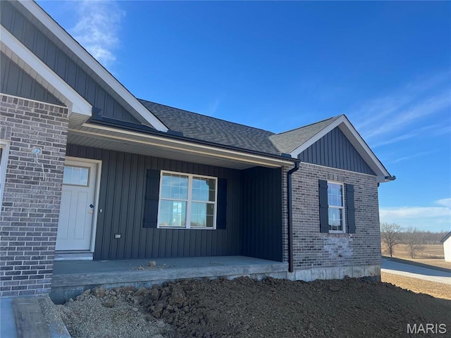 413 Byrd Ct, Jackson, MO 63755 - property entrance featuring covered porch, brick siding, board and batten siding, and roof with shingles