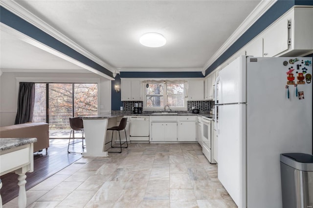 24950 State Rd A, Richland, MO 65556 - kitchen featuring white appliances, a peninsula, ornamental molding, tasteful backsplash, and a breakfast bar area