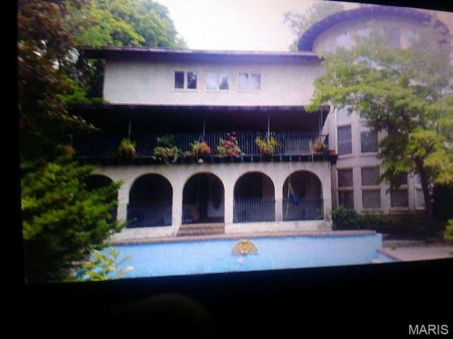 235 Quindaro Dr, Florissant, MO 63034 - rear view of house with a balcony and an outdoor pool