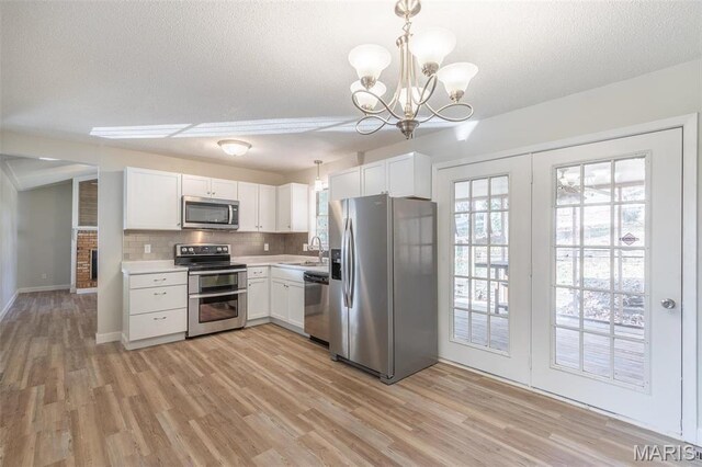 2637 Forest View St, Poplar Bluff, MO 63901 - kitchen with appliances with stainless steel finishes, a sink, light wood-style floors, light countertops, and white cabinetry