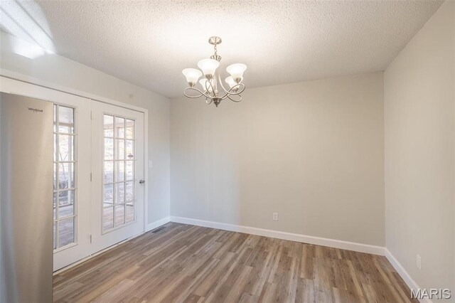 2637 Forest View St, Poplar Bluff, MO 63901 - unfurnished room with wood finished floors, a chandelier, baseboards, and a textured ceiling