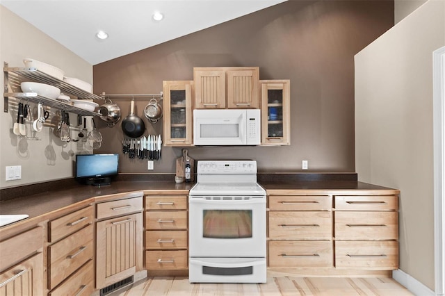 kitchen featuring white appliances, vaulted ceiling, light brown cabinets, glass insert cabinets, and dark countertops