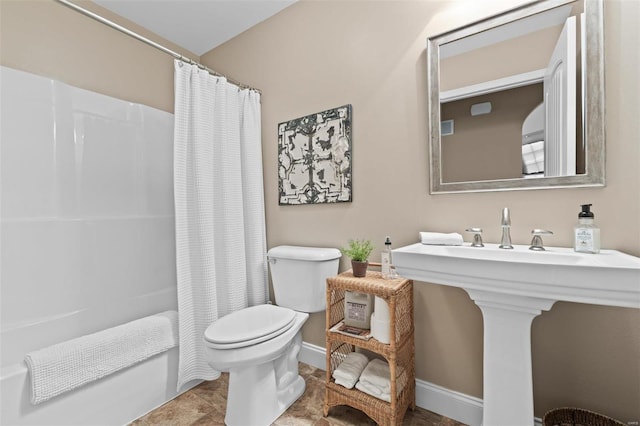 full bath featuring toilet, shower / bath combo with shower curtain, and baseboards