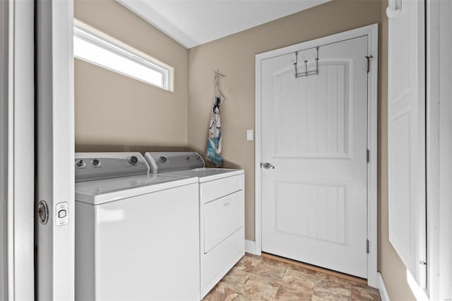 laundry room with independent washer and dryer, baseboards, and stone finish flooring