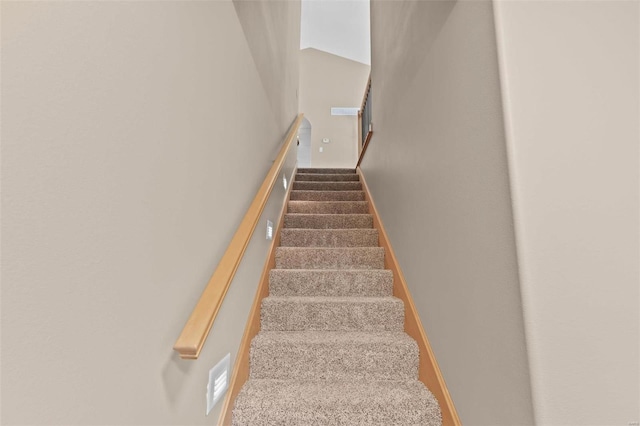 staircase with a high ceiling and baseboards