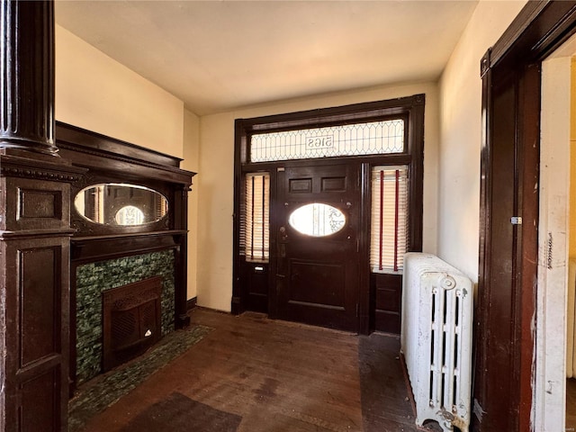 5168 Vernon Ave, Saint Louis, MO 63113 - entryway with radiator heating unit, dark wood-type flooring, and a tiled fireplace