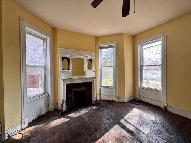 5168 Vernon Ave, Saint Louis, MO 63113 - unfurnished living room featuring ceiling fan, a fireplace with flush hearth, wood finished floors, and baseboards