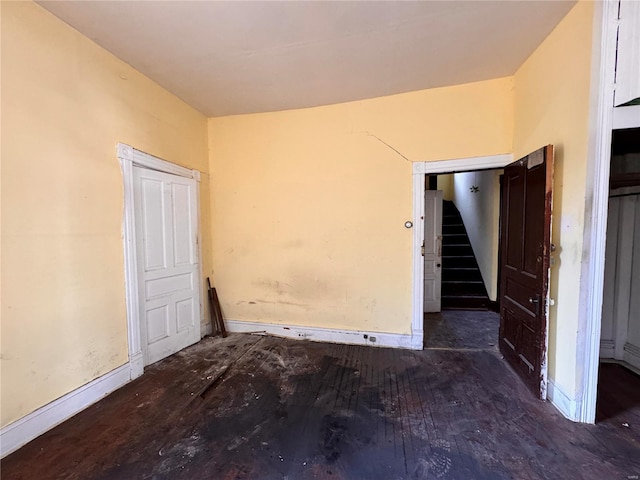 5168 Vernon Ave, Saint Louis, MO 63113 - unfurnished room with wood finished floors, baseboards, and stairway