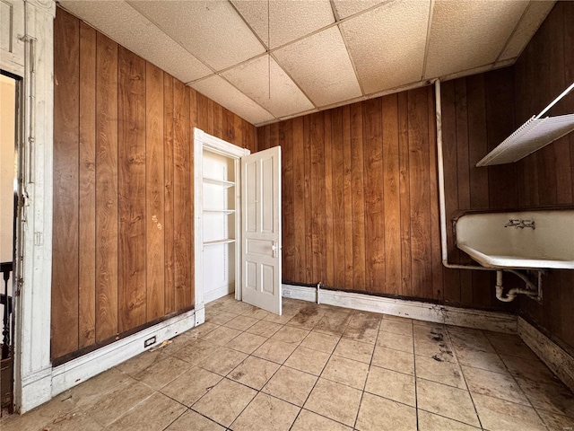 5168 Vernon Ave, Saint Louis, MO 63113 - spare room with wood walls, light tile patterned floors, and a drop ceiling
