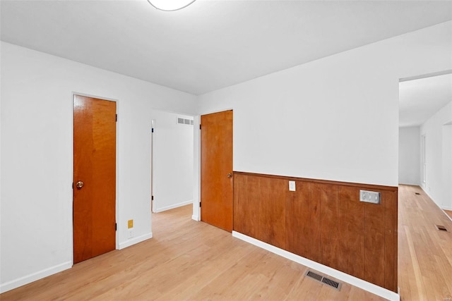 unfurnished room with light wood-type flooring and baseboards