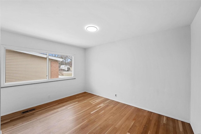 empty room with light wood-style flooring and baseboards