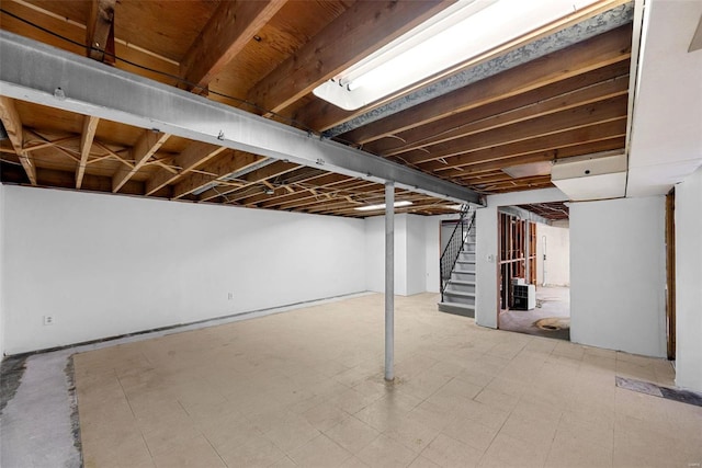 finished basement featuring stairway and tile patterned floors