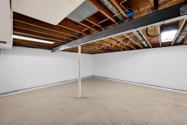 finished below grade area featuring tile patterned floors and baseboards