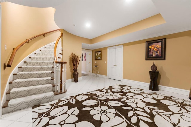 entrance foyer with stairs, light tile patterned floors, and baseboards